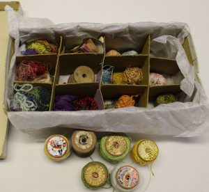 Reels of thread and loose thread in a box