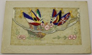 Embroidered postcard sent during World War One. This card is embroidered with the 6 flags of the Allied Forces. It is addressed 'To Harry'.