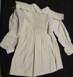 A white smock with embroidered detail at the front.