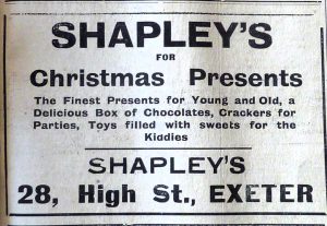 Newspaper advert reading 'Shapley's for Christmas Presents. the finest presents for young and old, a delicious box of chocolates, crackers for parties, toys filled with sweets for the kiddies. Shapley's 28 High Street, Exeter'.